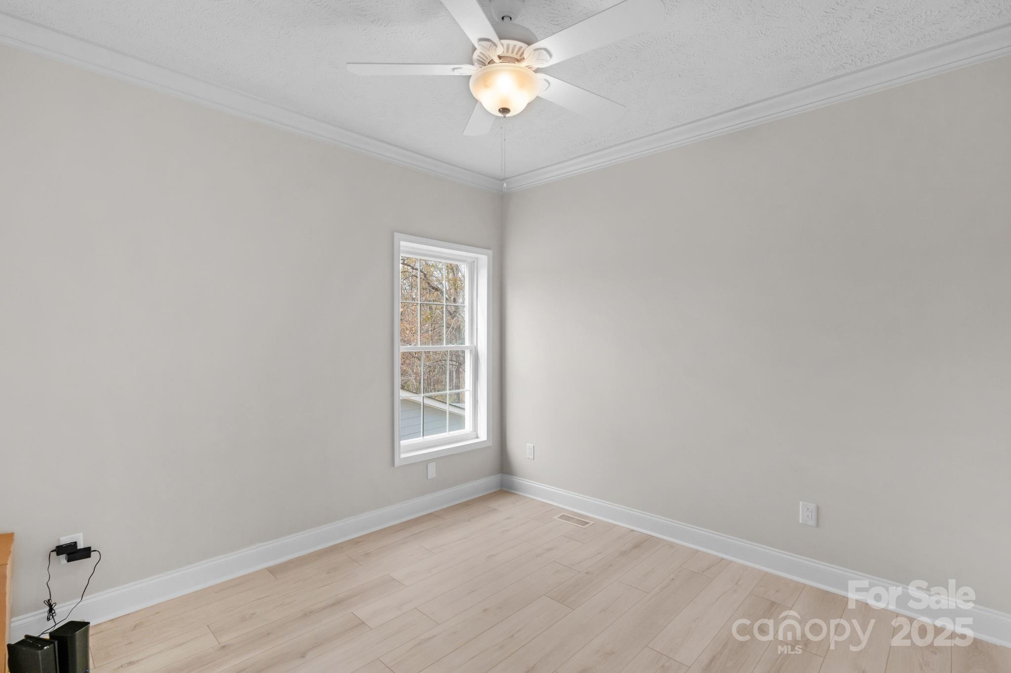 8891 Rock Hole Road Stanfield, NC 28163 - Photo 26 of 35 an empty room with windows and fan