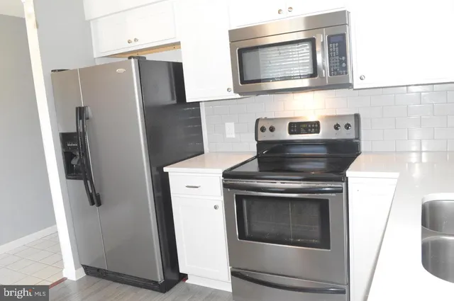 a stove top oven sitting inside of a kitchen