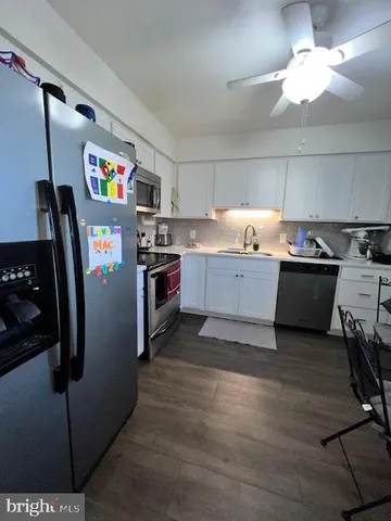 a kitchen with stainless steel appliances granite countertop a refrigerator a stove and a sink