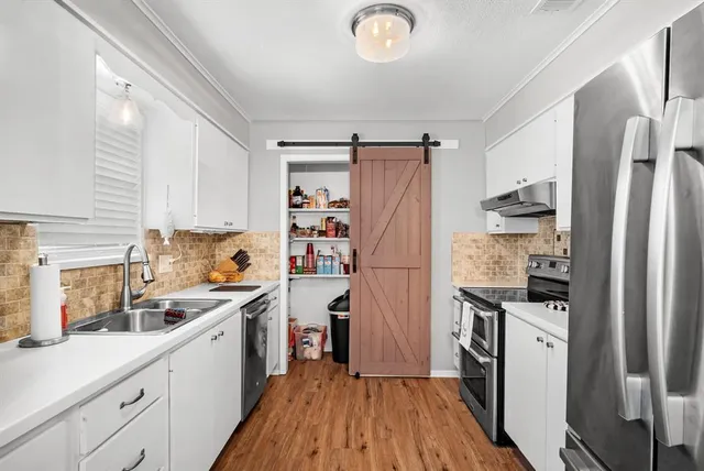 a kitchen with white cabinets and stainless steel appliances