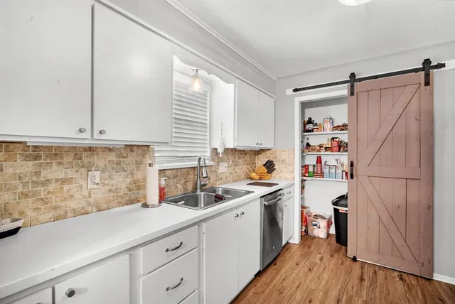 a kitchen with a sink a refrigerator a window and cabinets