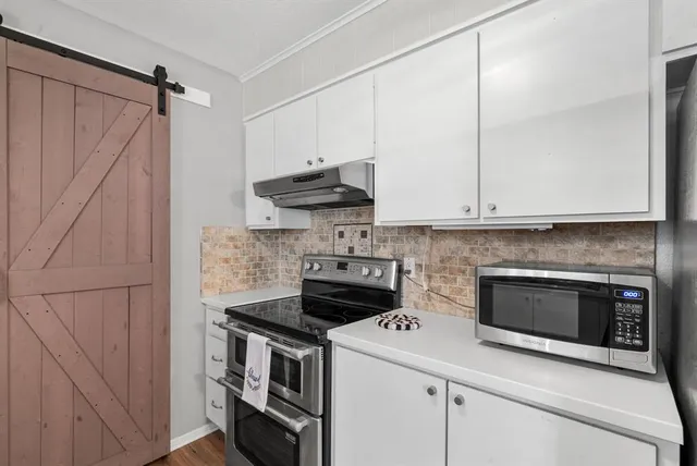 a kitchen with stainless steel appliances granite countertop a stove and a microwave