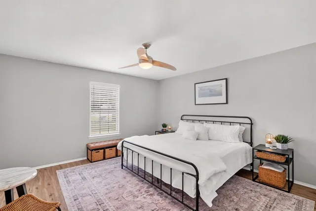 a bedroom with a bed a chandelier and a window