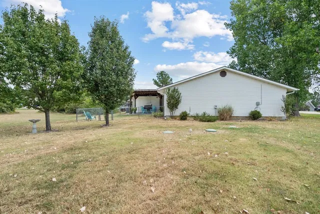 a view of a house with backyard and tree