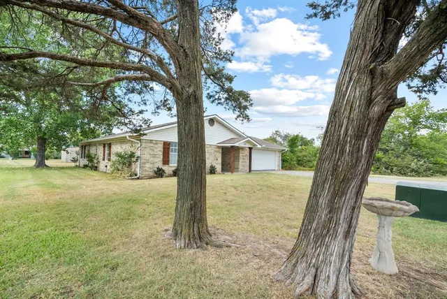 a view of a house with a tree in the yard