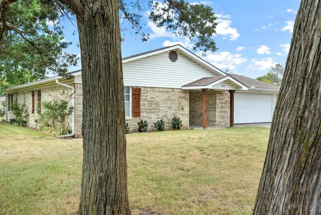 a yellow house with trees in front of it