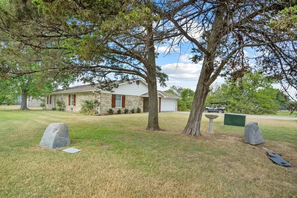 a front view of a house with a yard garage and tree