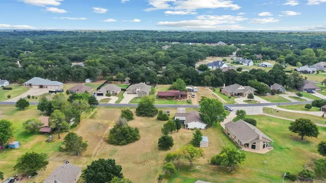 an aerial view of residential houses with outdoor space and trees