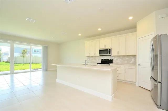 a kitchen with stainless steel appliances a refrigerator and a stove top oven