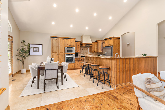 552 East Johns Way Sandy, UT 84070 - Photo 18 of 67 Wood-finish cabinetry, stainless steel appliances, and a central island with bar seating