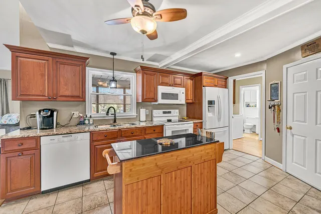 a large kitchen with stainless steel appliances granite countertop a stove a sink dishwasher and a refrigerator
