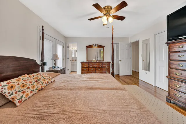 a spacious bedroom with a bed and a flat screen tv