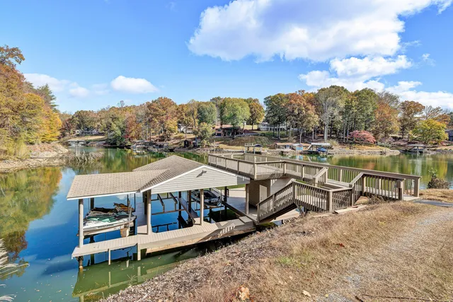 an aerial view of lake residential house with outdoor space and trees around