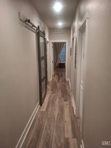 a view of a hallway with wooden floor