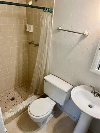 a white toilet sitting next to a bathroom sink