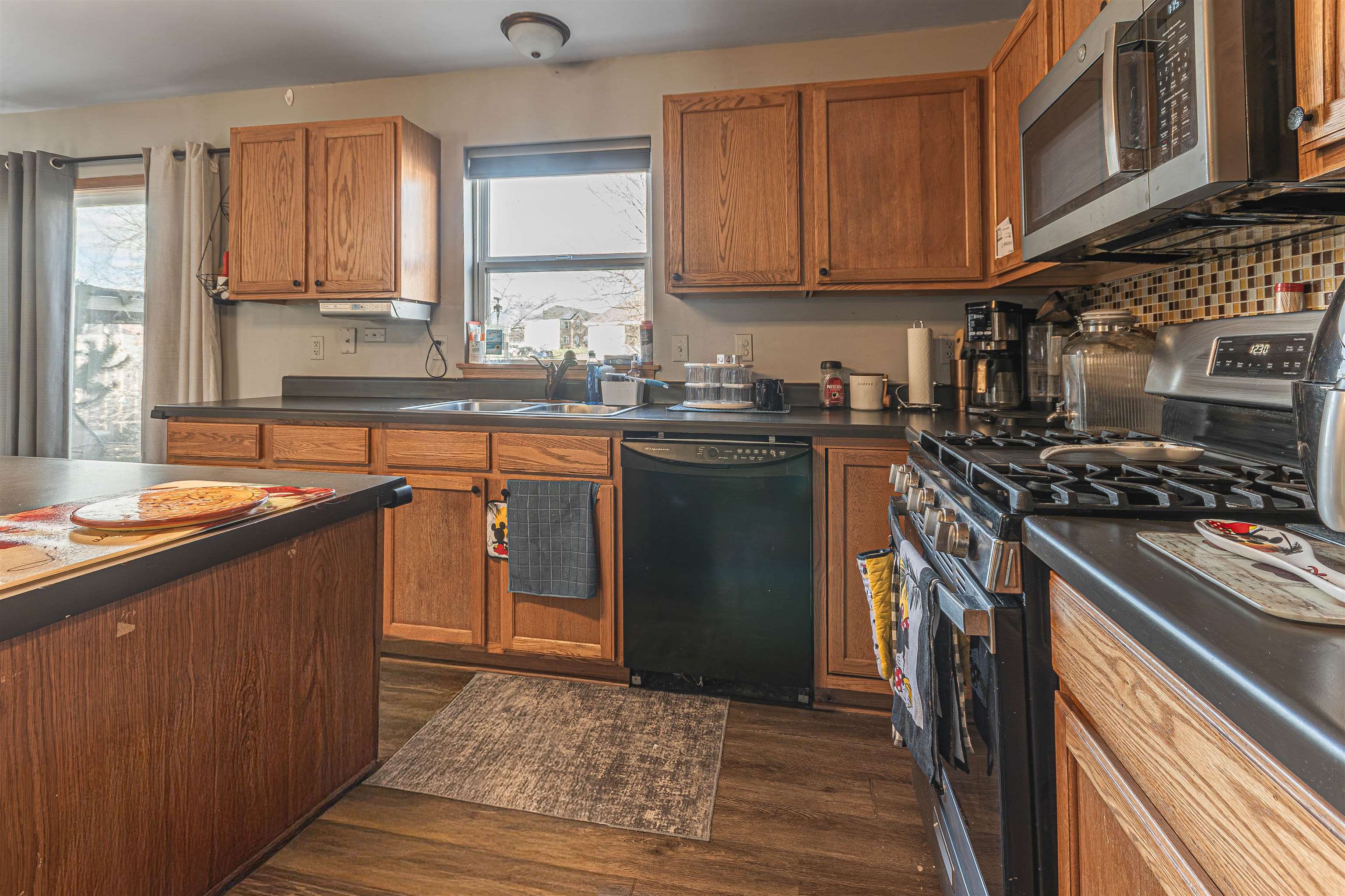738 Trent Lane Loves Park, IL 61111 - Photo 17 of 37 a kitchen with stainless steel appliances granite countertop a stove a sink dishwasher and a microwave oven with wooden cabinets