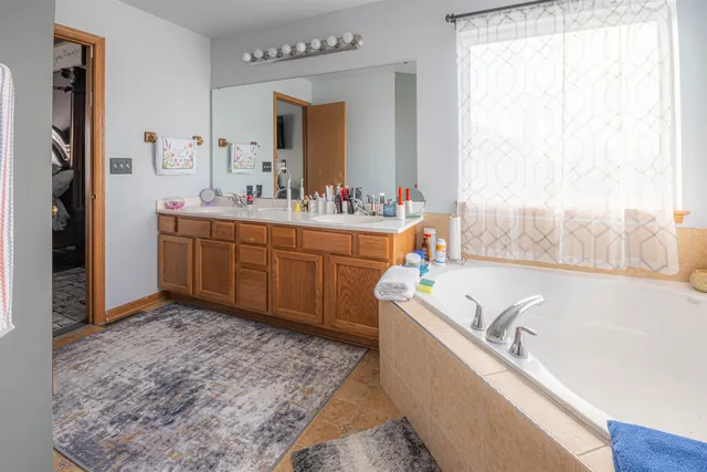 a bathroom with a tub sink and mirror