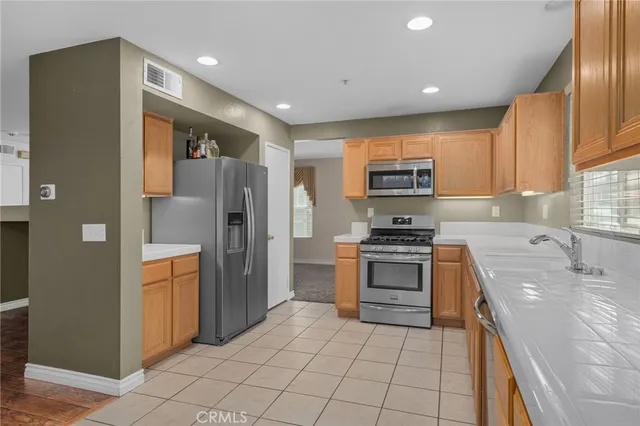 a kitchen with granite countertop a refrigerator and a stove top oven