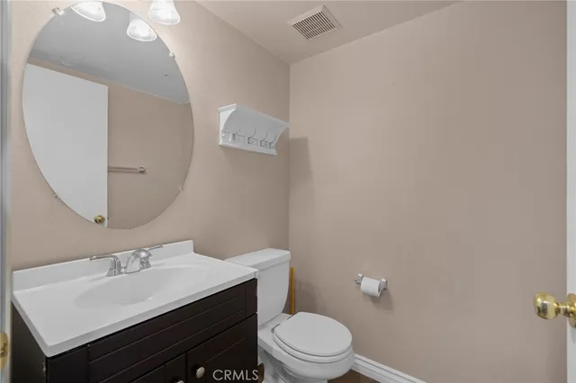 a bathroom with a sink mirror vanity and toilet