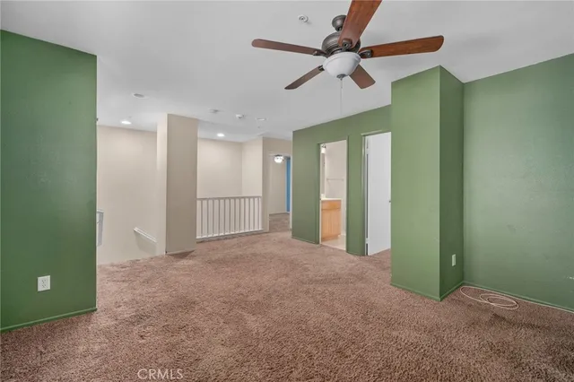 a view of a big room with a ceiling fan and a large window