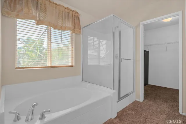 a white bath tub sitting in a bathroom next to a window