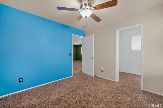 en empty room with fan and a ceiling fan