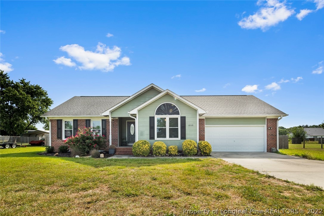 8209 Rockfish Road Raeford, NC 28376 - Photo 1 of 42 a front view of a house with a yard and garage