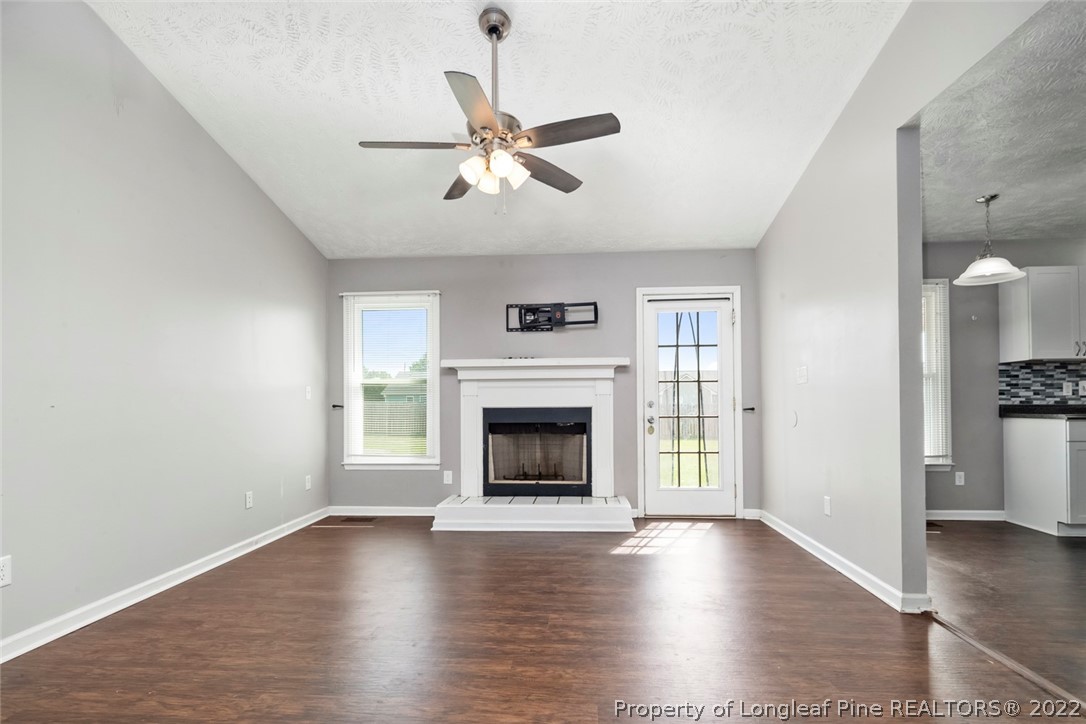 8209 Rockfish Road Raeford, NC 28376 - Photo 15 of 42 a view of an empty room with wooden floor fireplace and a window