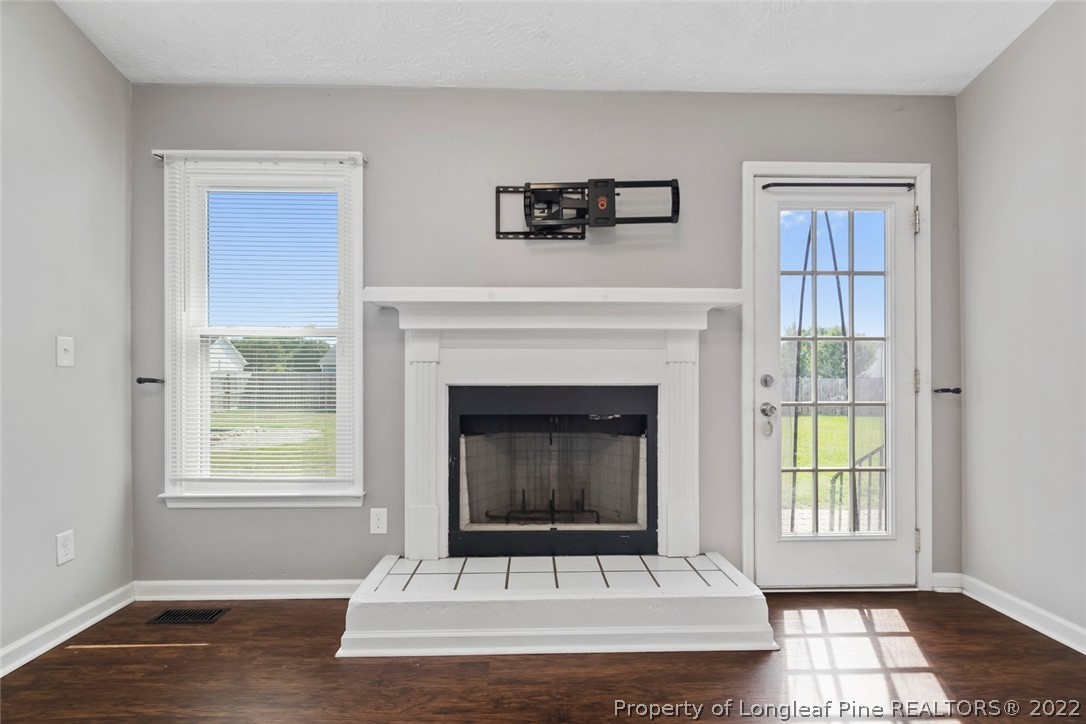 8209 Rockfish Road Raeford, NC 28376 - Photo 16 of 42 a living room with a fireplace and a window