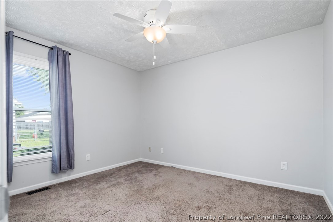 8209 Rockfish Road Raeford, NC 28376 - Photo 24 of 42 an empty room with a window and a ceiling fan