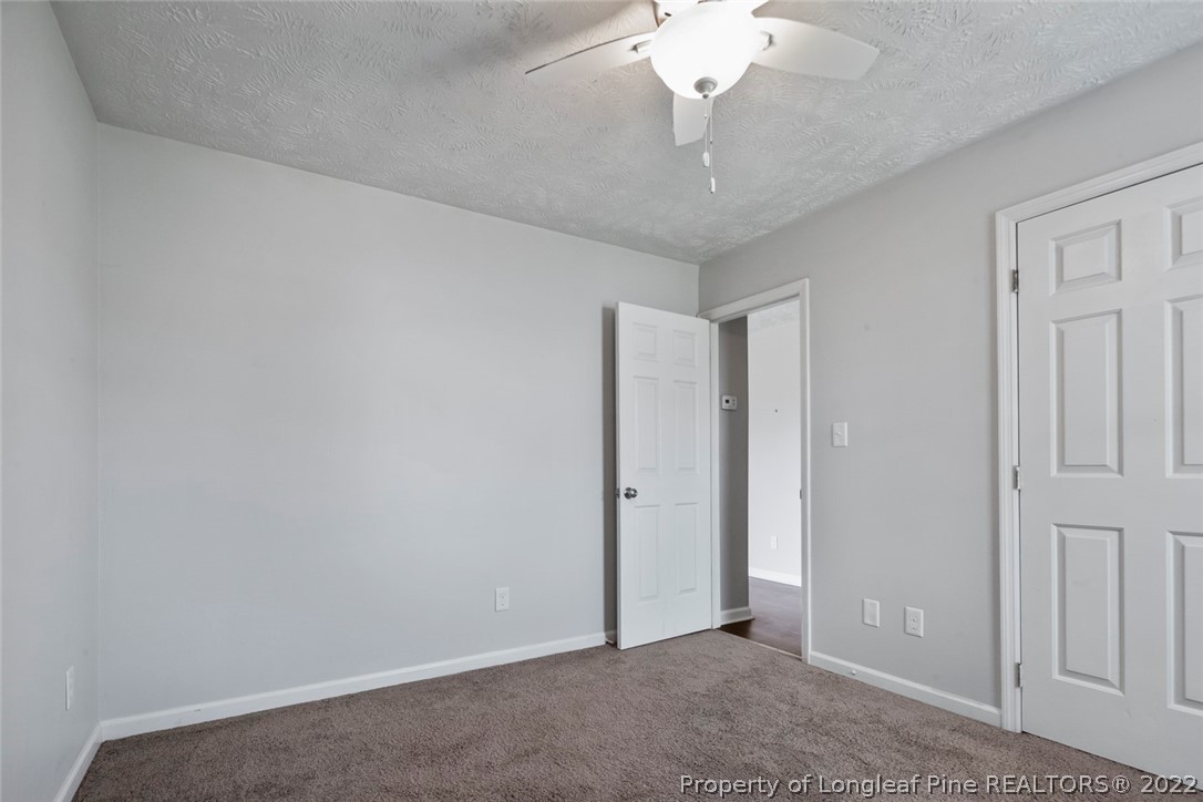 8209 Rockfish Road Raeford, NC 28376 - Photo 25 of 42 an empty room with a chandelier fan