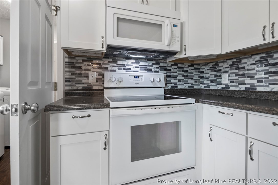8209 Rockfish Road Raeford, NC 28376 - Photo 28 of 42 a kitchen with granite countertop white cabinets and white appliances