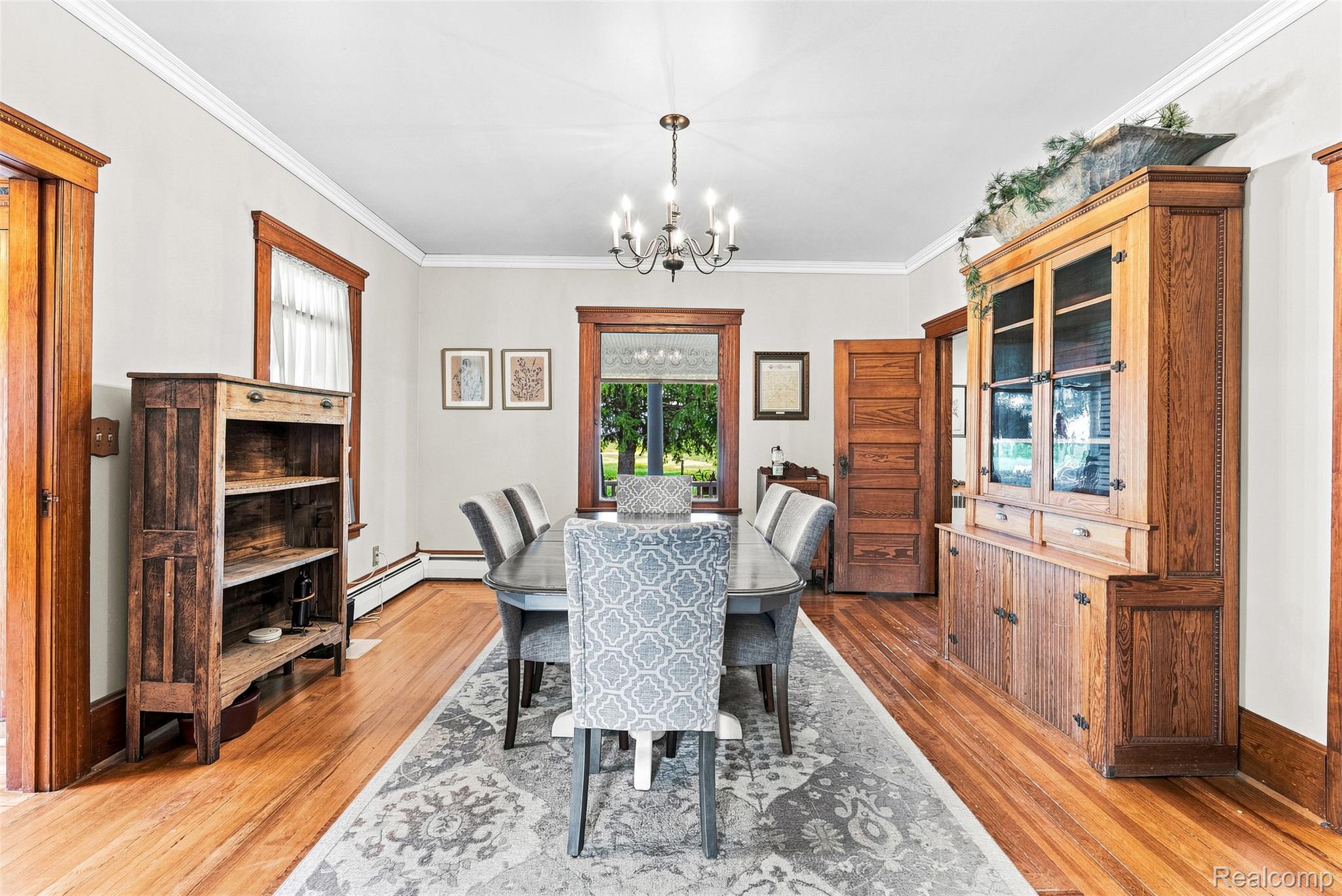 2971 Huron Line Road Cass City, MI 48726 - Photo 12 of 63 Hardwood flooring, crown molding, chandelier, built-in wooden hutch, and wooden door