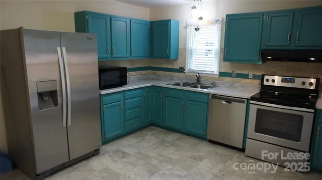 a kitchen with stainless steel appliances granite countertop a refrigerator sink and cabinets