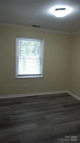 a room with wooden floor and windows