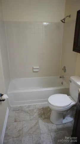 a white toilet sitting next to a bath tub and a shower