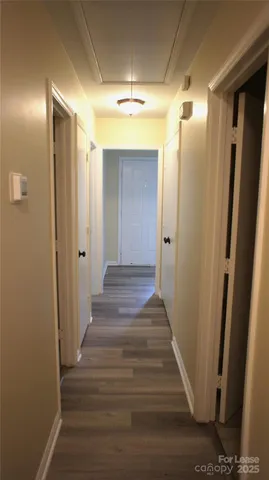 a view of a hallway with wooden floor and staircase