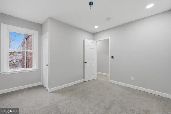 an empty room with windows and closet