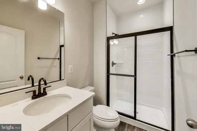 a bathroom with a sink toilet a mirror and shower