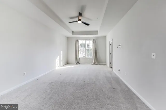 en empty room with windows and ceiling fan