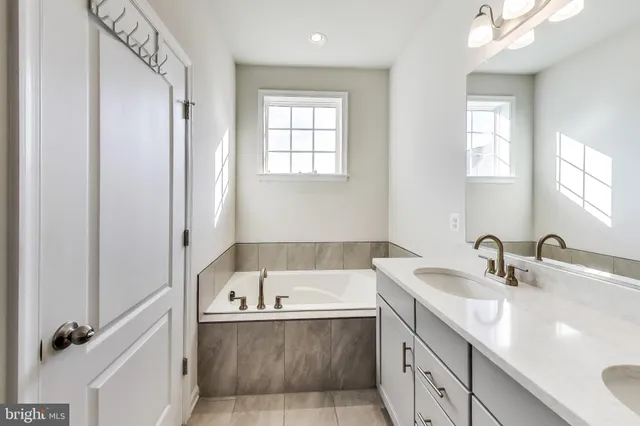 a bathroom with a tub sink and mirror