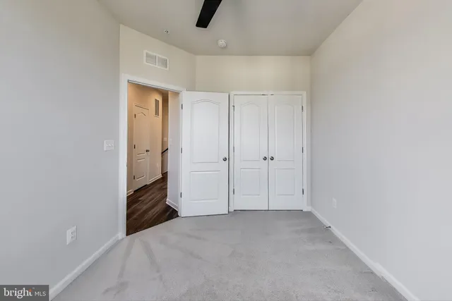 an empty room with closet and windows