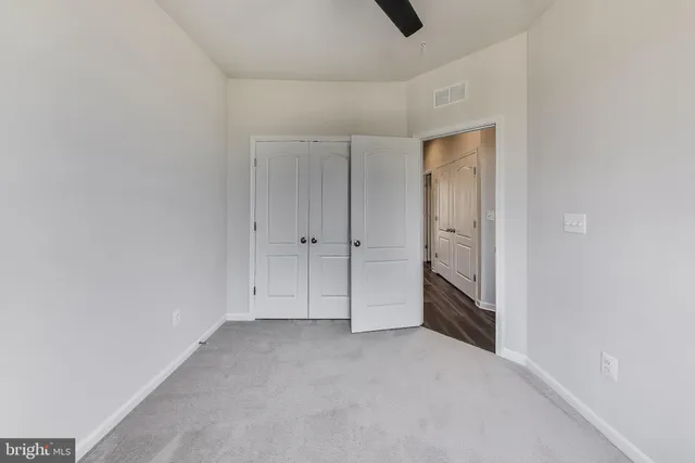 an empty room with closet and windows