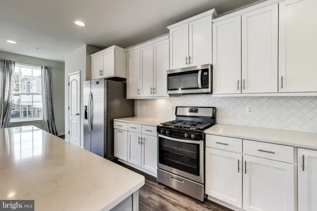 a kitchen with stainless steel appliances granite countertop a stove a refrigerator and a microwave