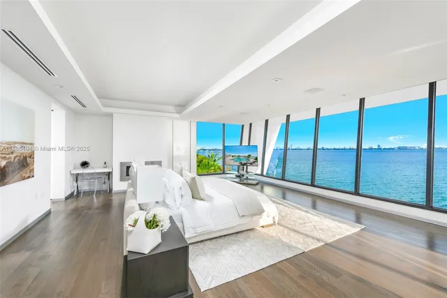 a spacious bedroom with a large bed and a wooden floor