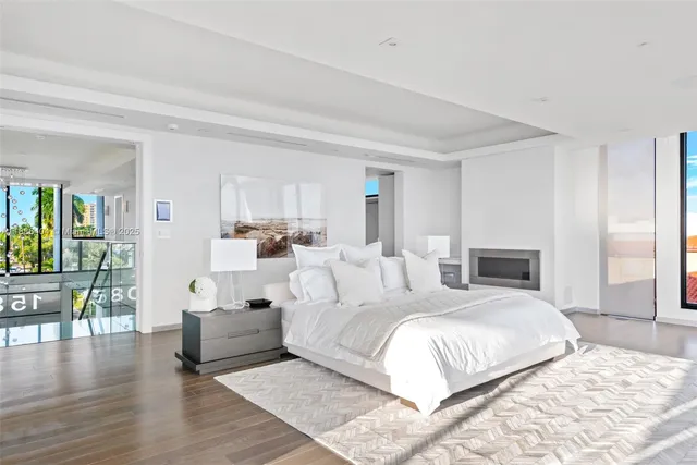 a bedroom with a large white bed and white walls