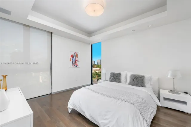 a bedroom with a bed and a wooden floor