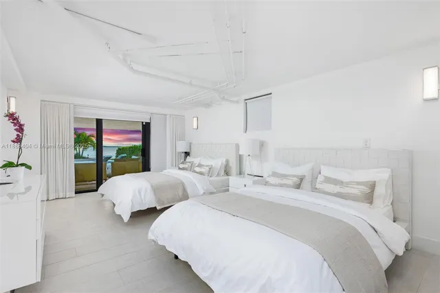 a bedroom with two beds and a potted plant