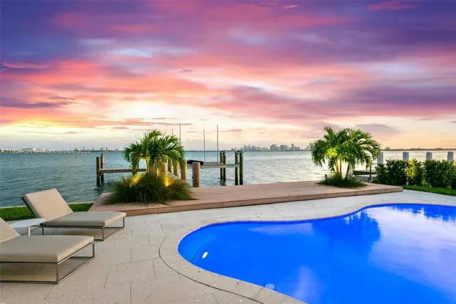 a view of swimming pool with seating space and lake view