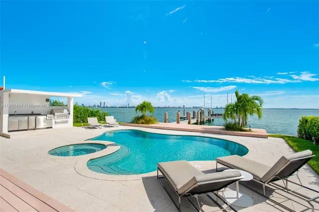 a view of a swimming pool with lawn chairs under an umbrella